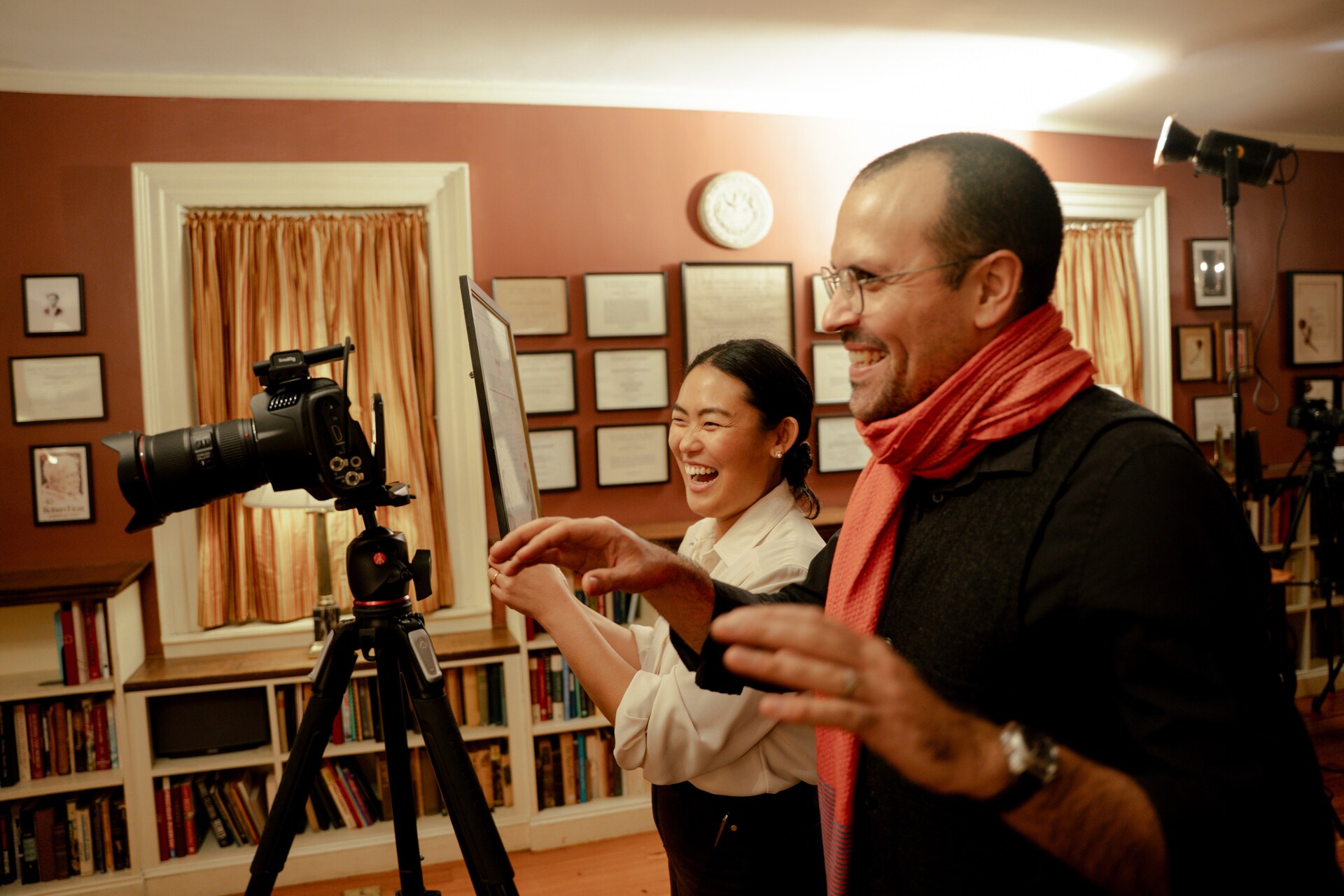 Grace Sun laughing with a crew member beside a cinema camera.