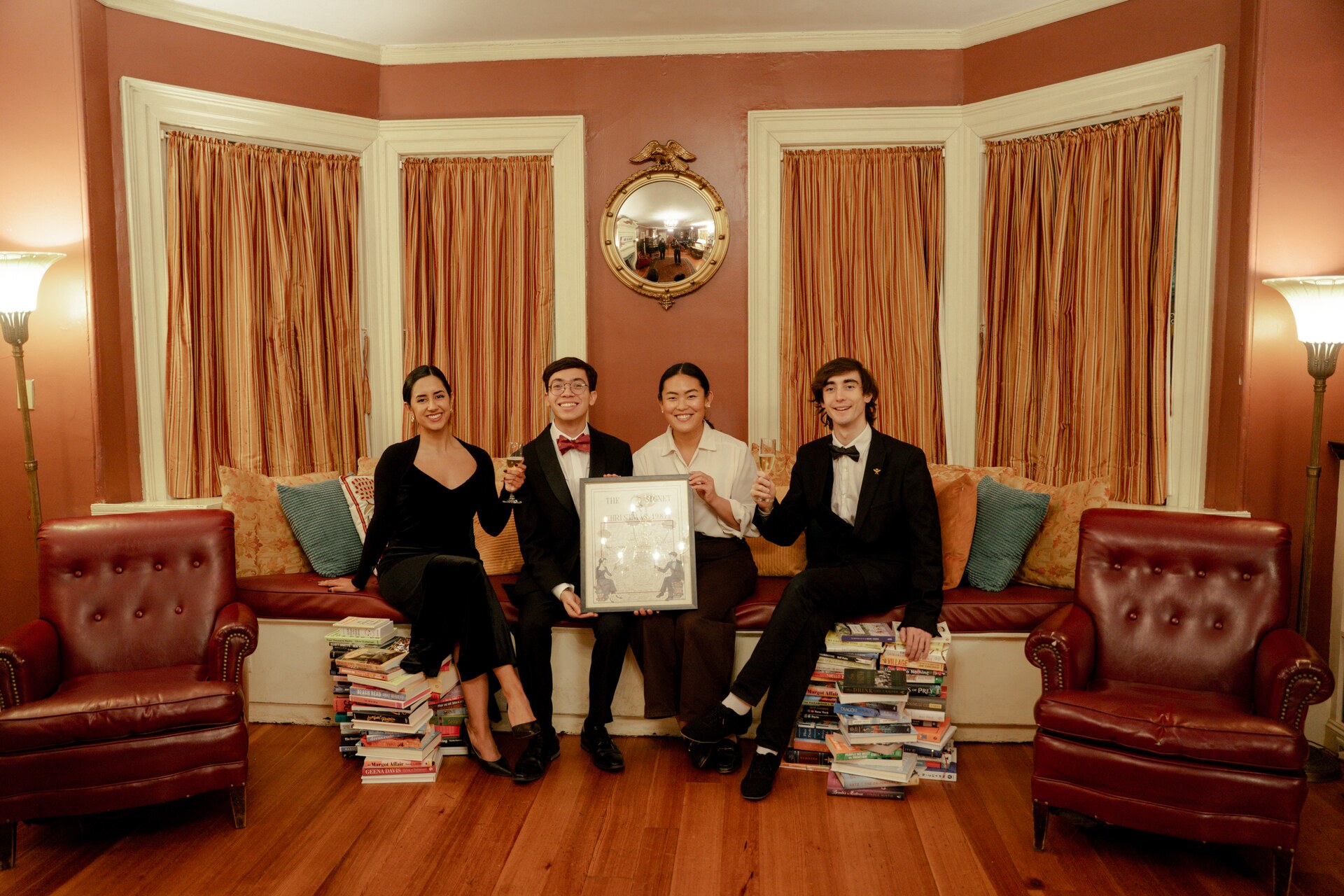 Four performers posing with a framed illustration in the Signet Society.