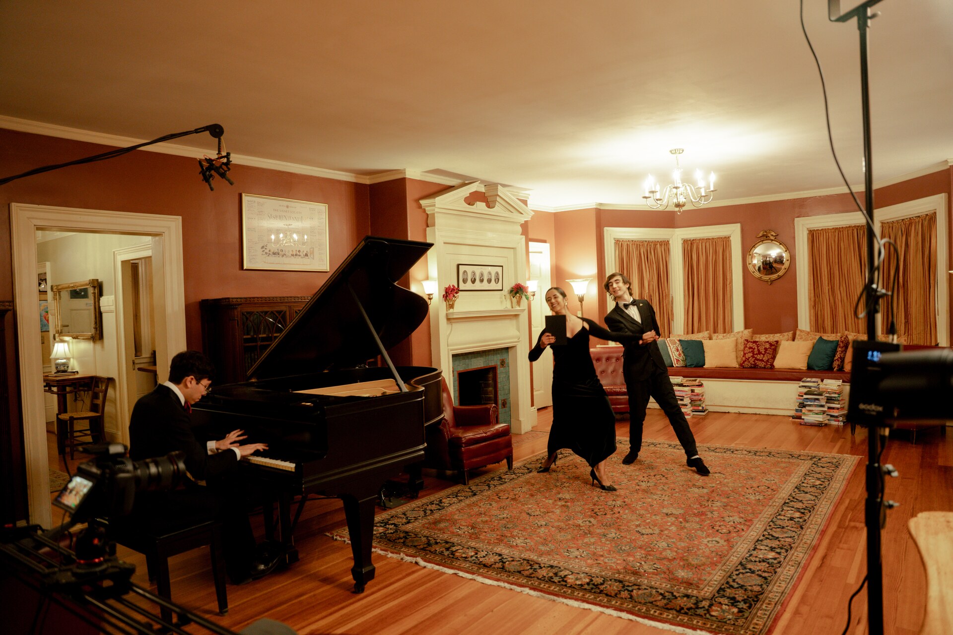 Wide behind-the-scenes view of performers and a pianist in the Signet Society.