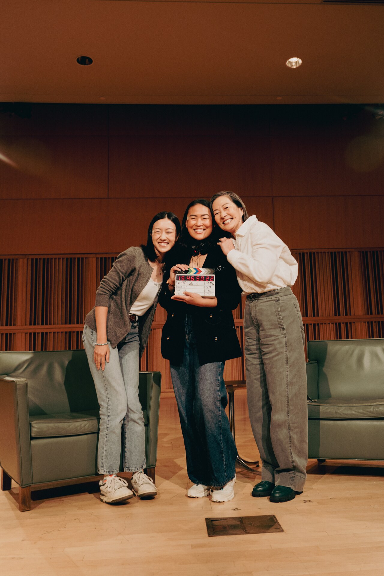 Three Book Talk team members posing together in an auditorium.
