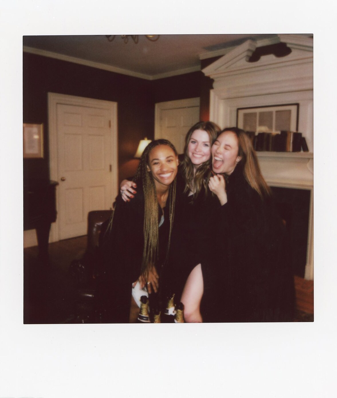 Four friends posing together in a candid Commencement Eve Polaroid.