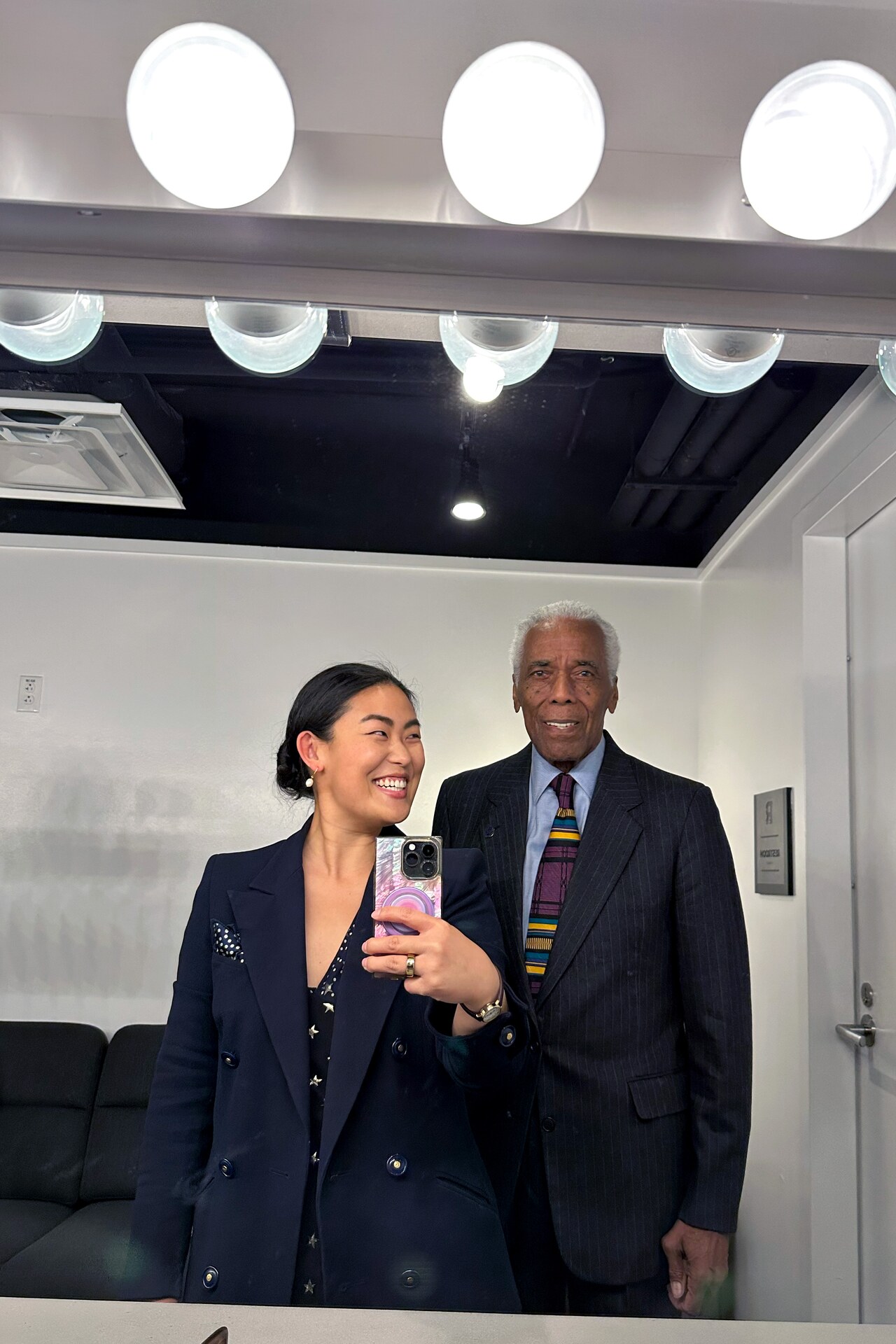 Grace Sun and Robert Hooks reflected together in a dressing-room mirror.