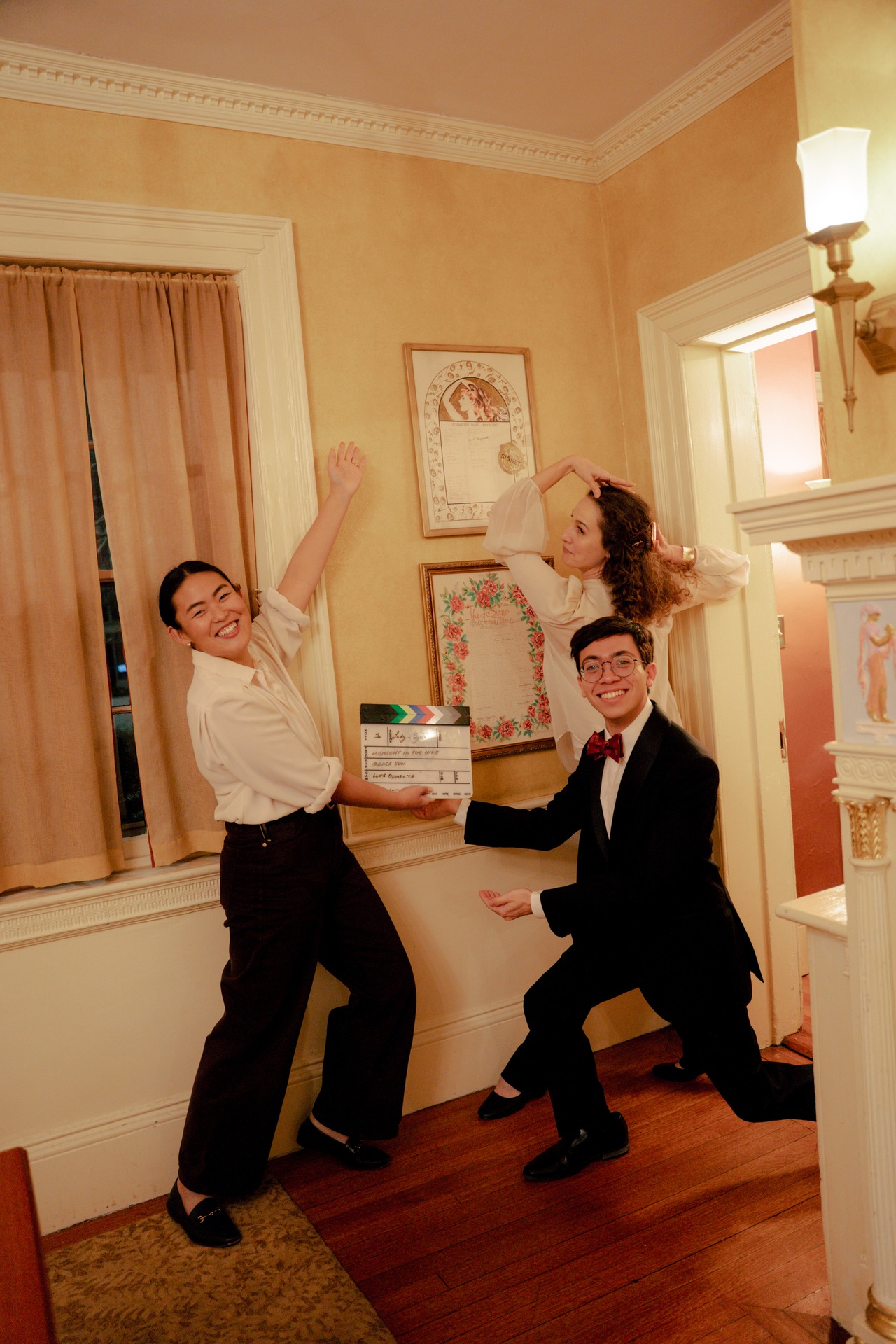 Three people celebrating together in a bright room.