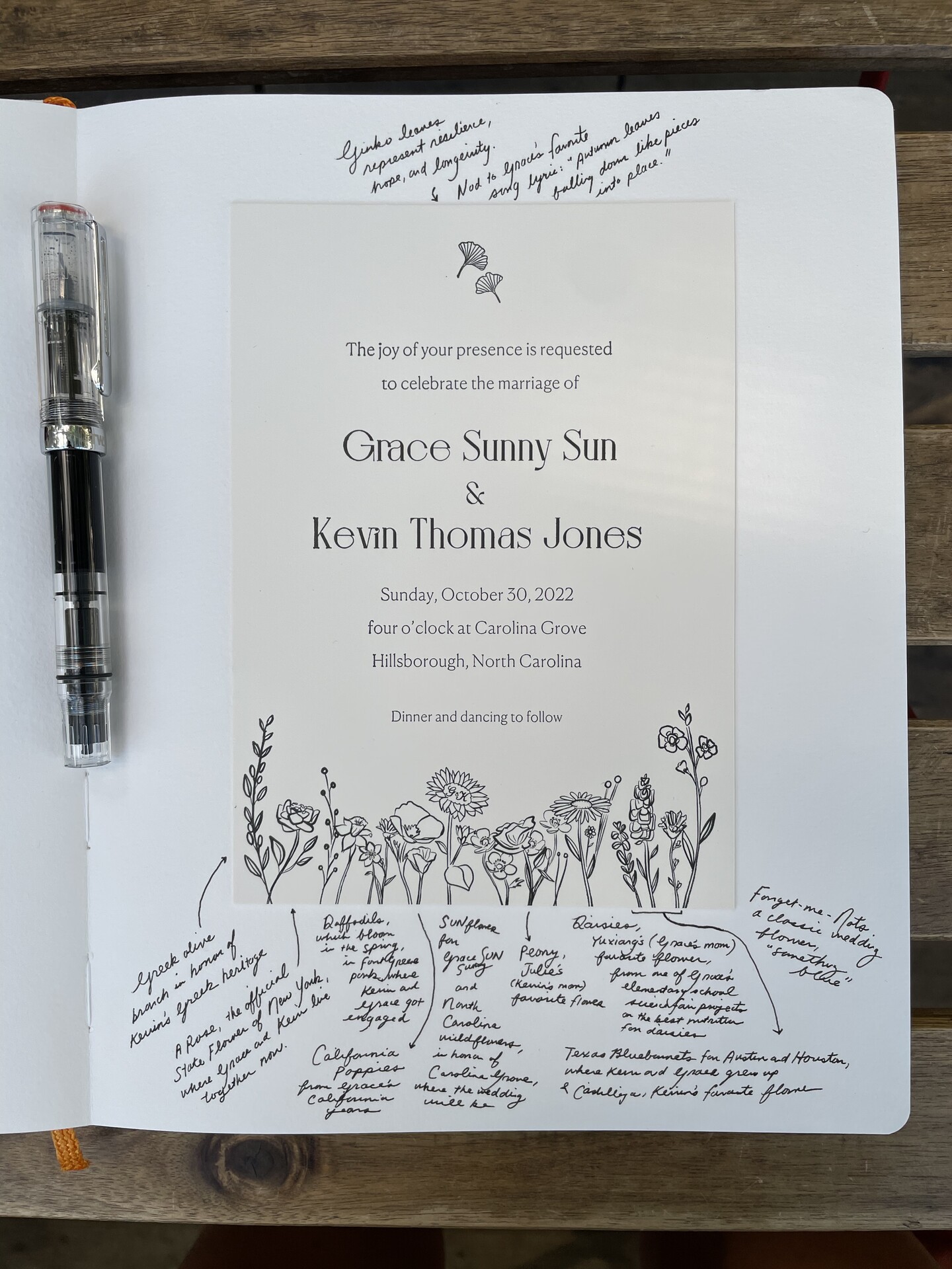 Wedding invitation for Grace Sunny Sun and Kevin Thomas Jones displayed in a sketchbook with handwritten flower notes.